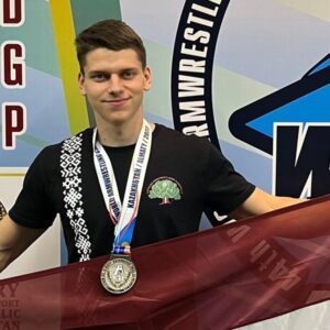 Kristaps Blūmanis ar Latvijas karogu un medaļu 2023. gada Pasaules čempionātā Almati